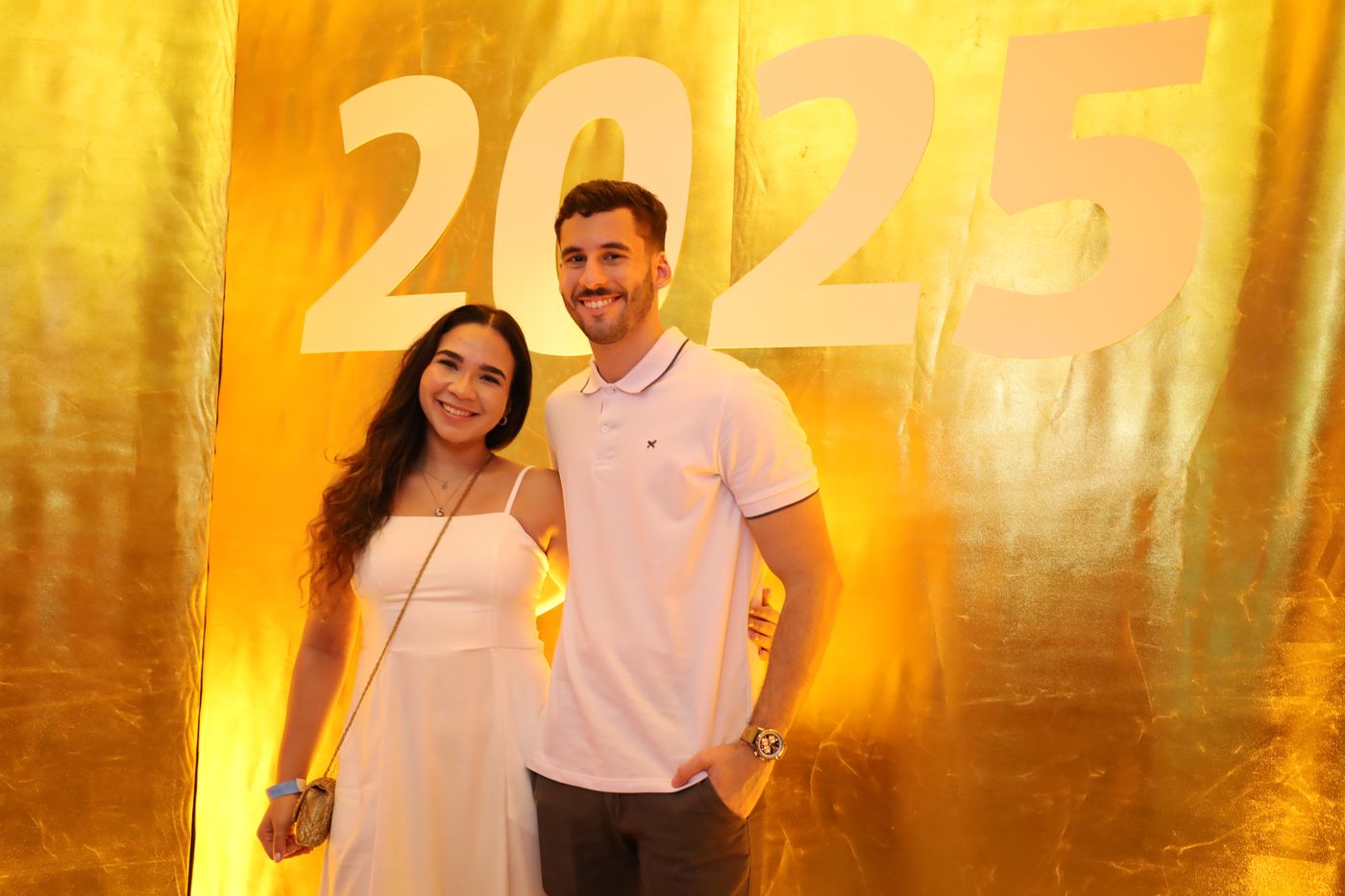 Casal no painel dourado de 2025