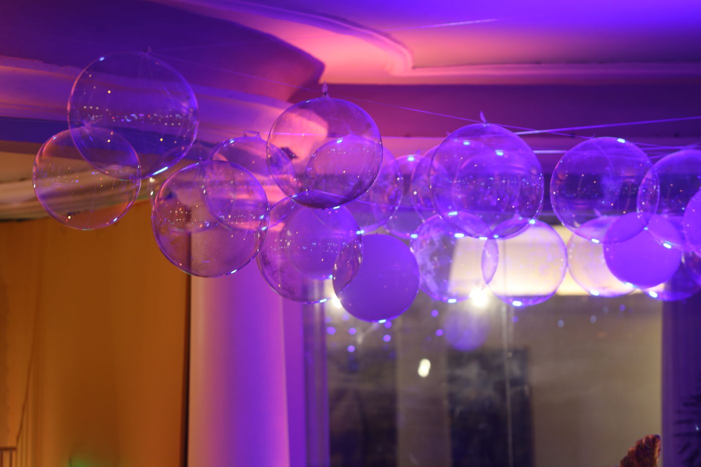 Teto decorado com esferas transparentes em luz lilás
