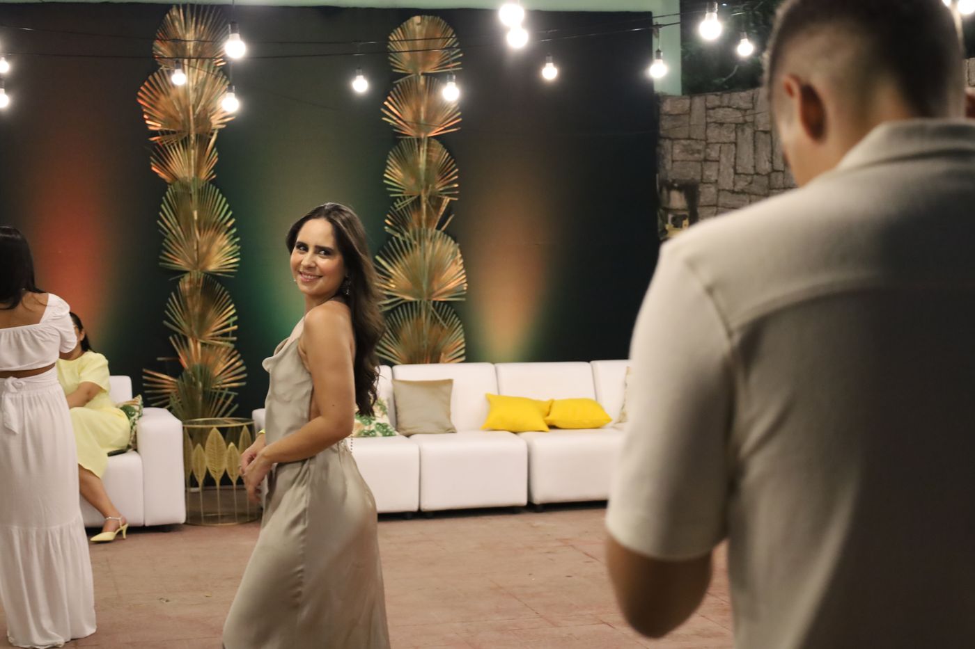 Convidada no lounge decorado com palmeiras douradas