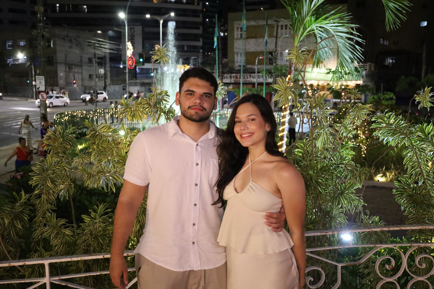 Casal no jardim do clube, com a fonte ao fundo