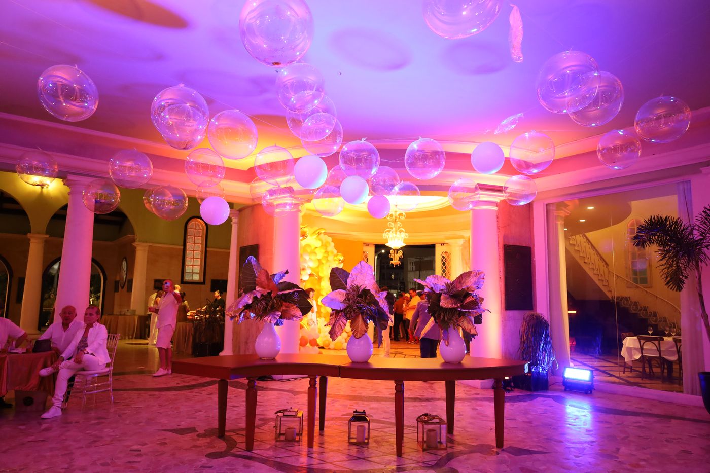 Salão decorado com luz rosa e balões transparentes