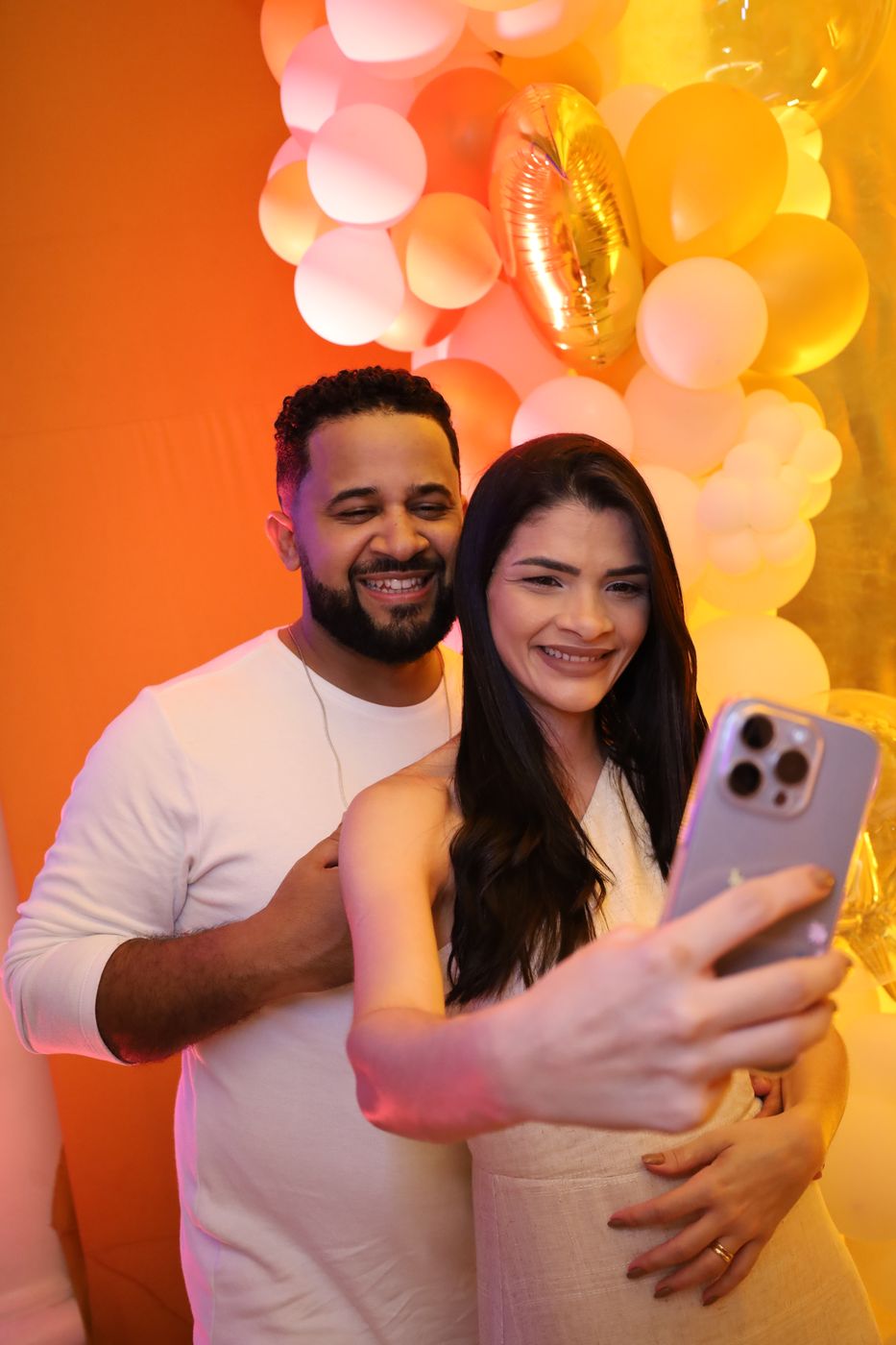 Casal fazendo selfie no painel de balões